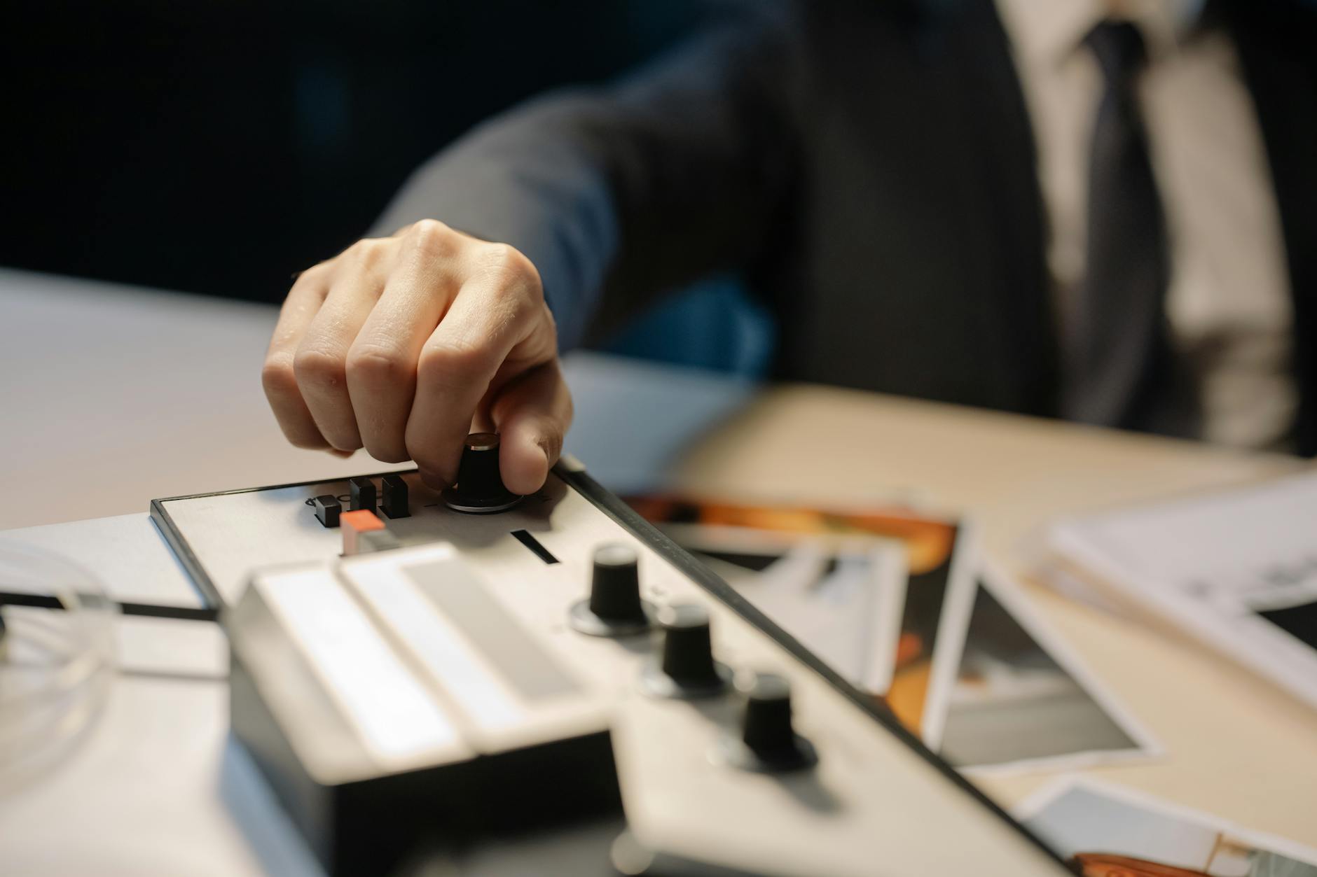 Dłoń śledczego regulująca pokrętła starego magnetofonu szpulowego