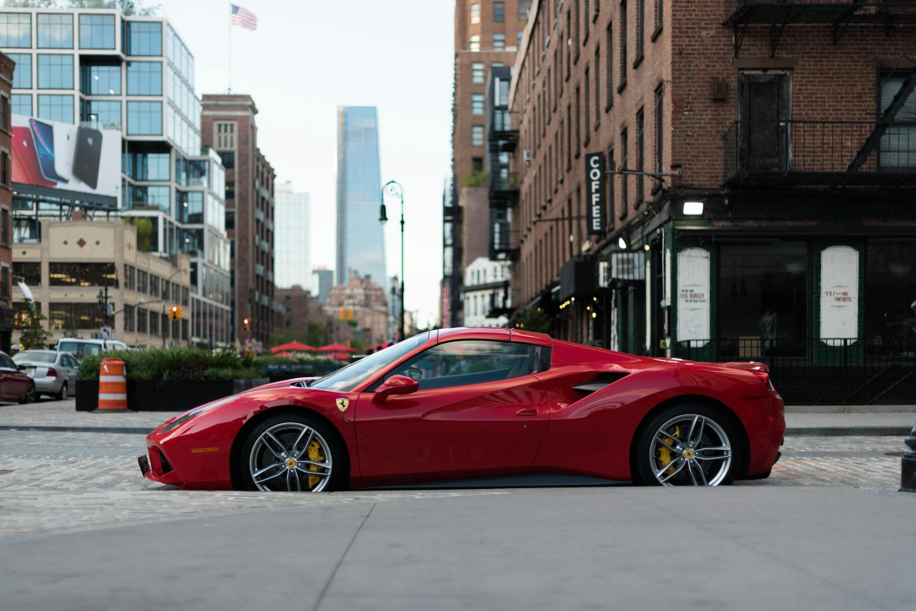 Czerwone Ferrari zaparkowane na ulicy wśród nowojorskich wieżowców