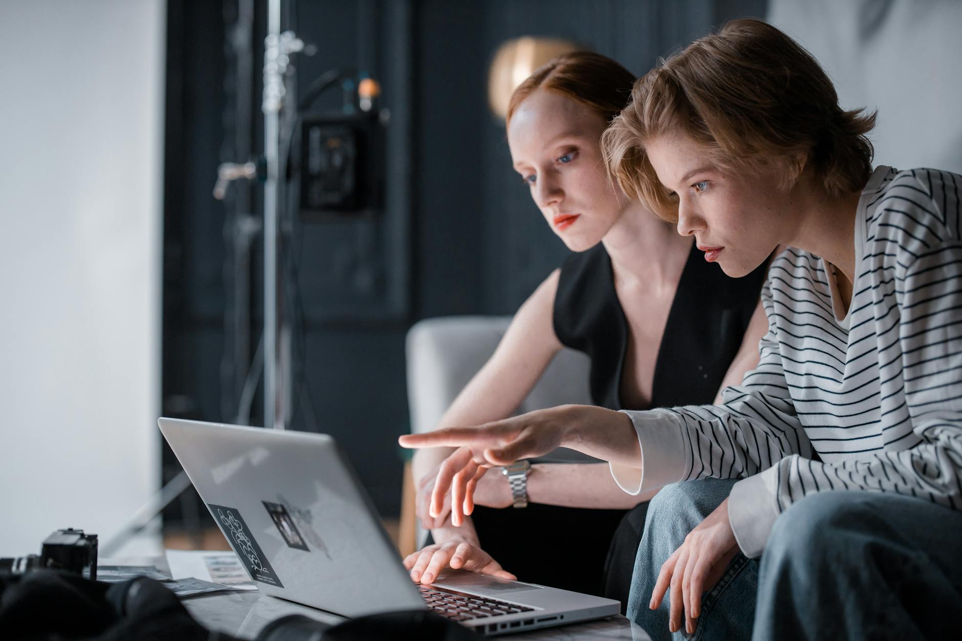Dwie osoby programują wspólnie przy laptopie w biurze