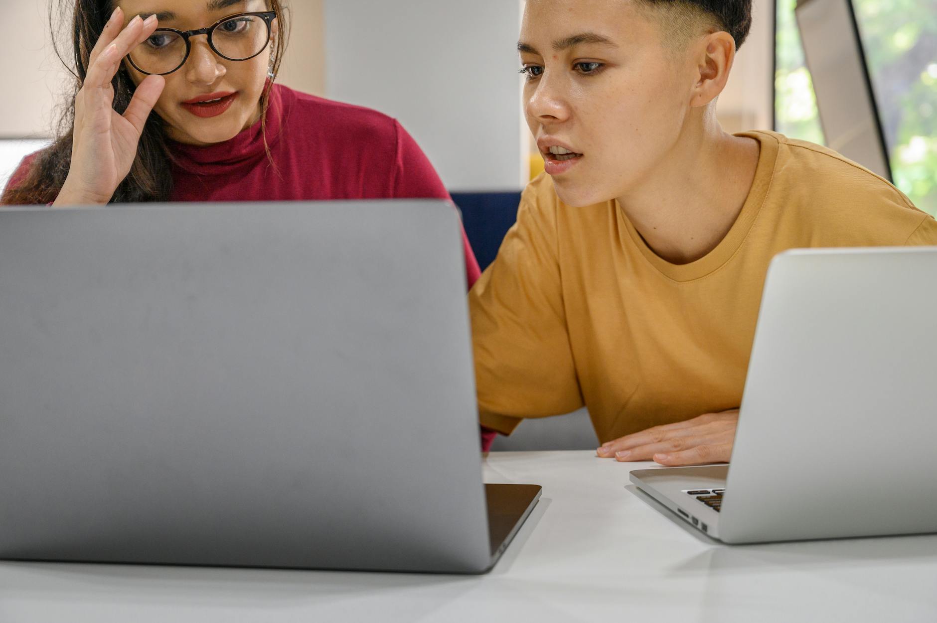 Dwóch programistów współpracuje przy laptopach nad projektem Docker