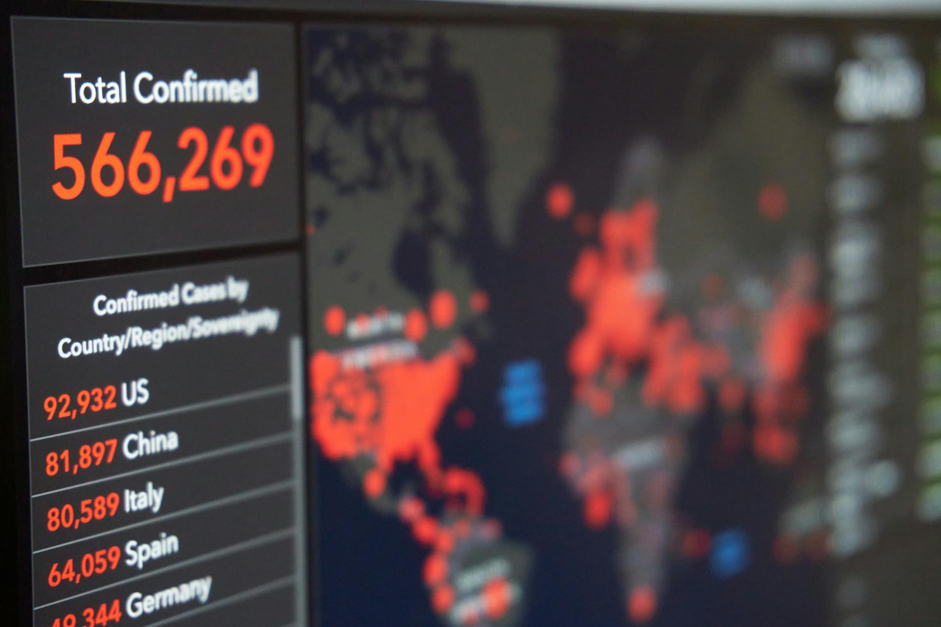 Ekran smartfona z mapą świata i statystykami przypadków COVID-19