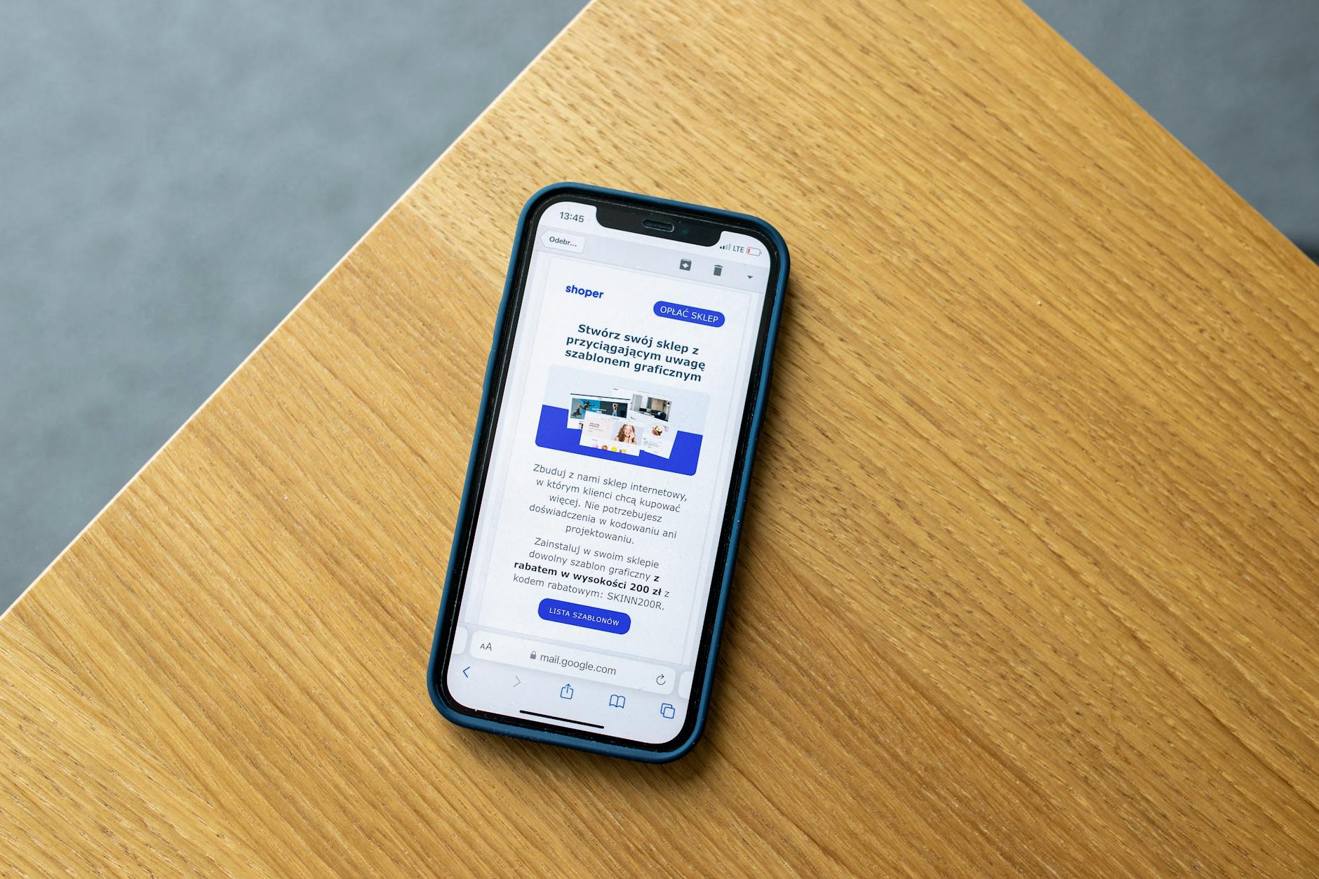 Smartfon z interfejsem sklepu internetowego leżący na drewnianym blacie