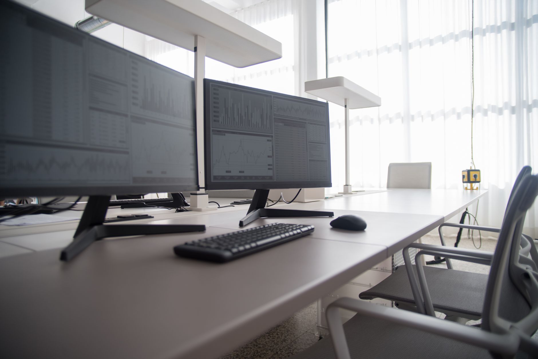 Nowoczesne biuro z kilkoma monitorami komputerowymi i krzesłami ergonomicznymi
