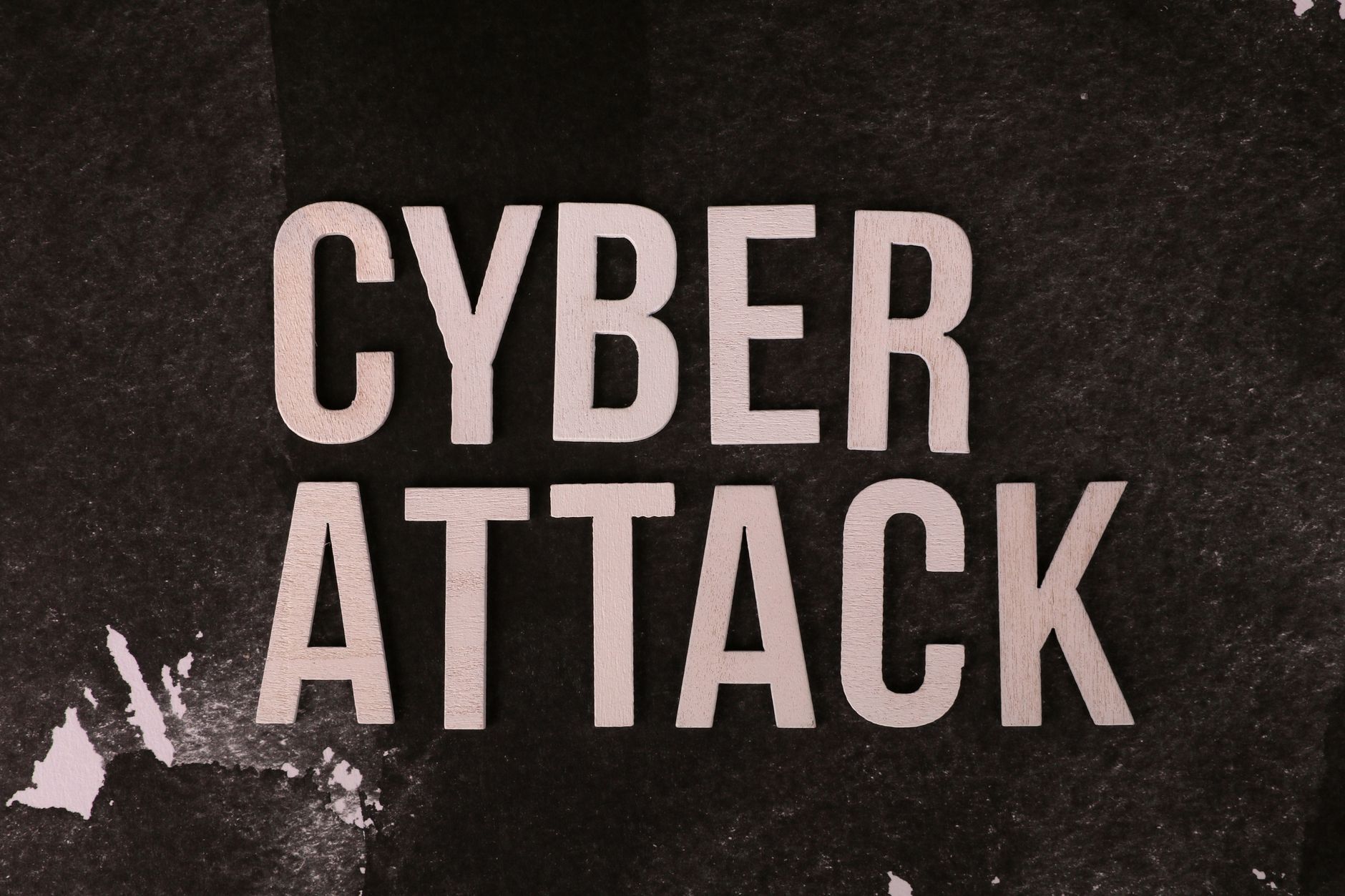 Napis Cyber Attack na ciemnym tle symbolizujący zagrożenia cyfrowe