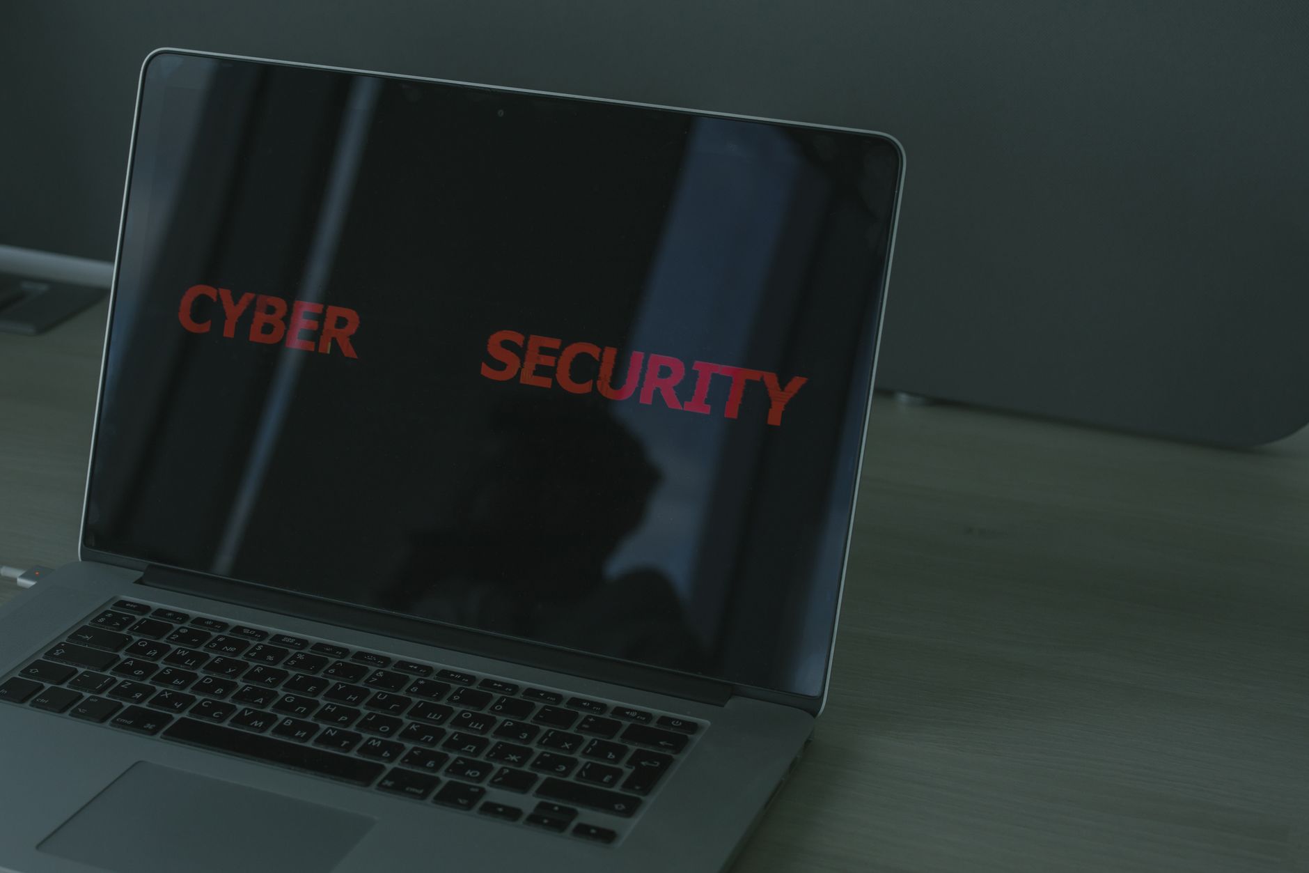 Zbliżenie na ekran laptopa z napisem cybersecurity i motywem ochrony danych